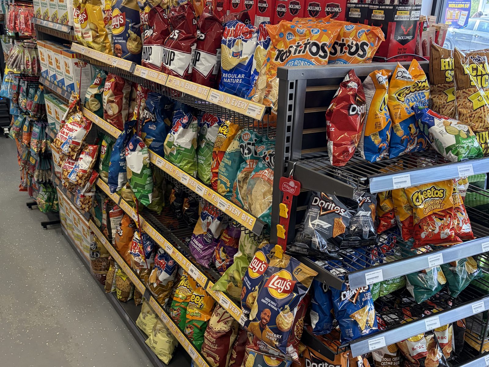 The snack wall: shelves stacked with chips, jerky sticks, and candy